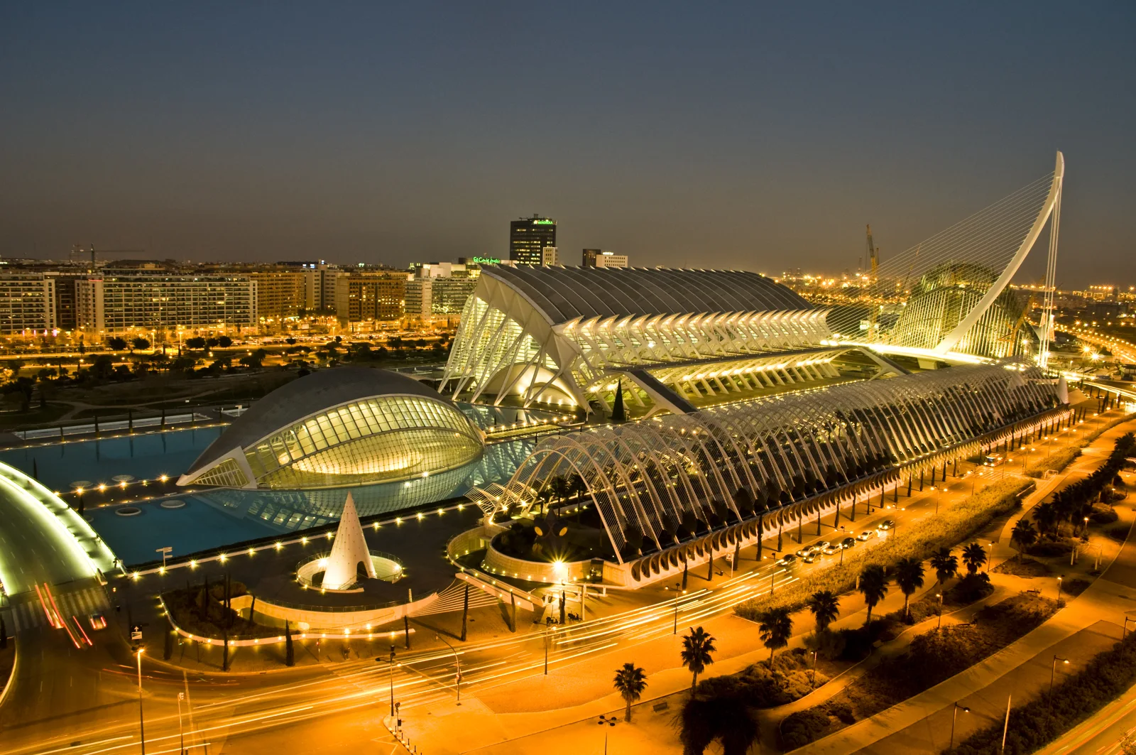 City of Arts and Sciences in Valencia illuminated at dusk, with surrounding city buildings